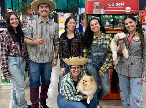 Equipe da Bicho Chic vestida de festa junina na loja, com dois cachorros