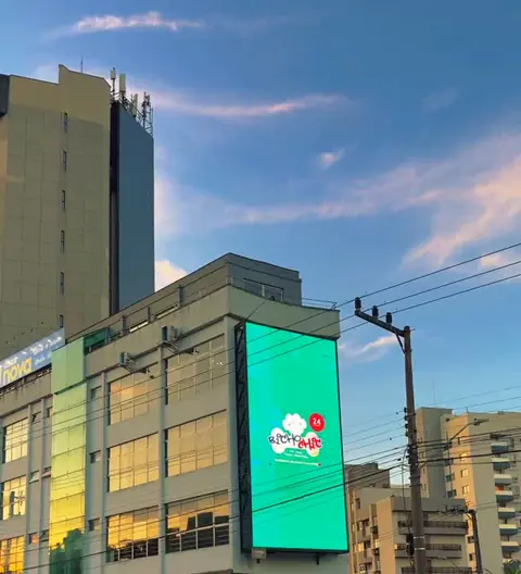 Prédio da Bicho Chic com o painel iluminado ao anoitecer